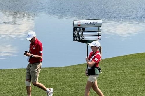 Houston Open workers displaying current scores for players